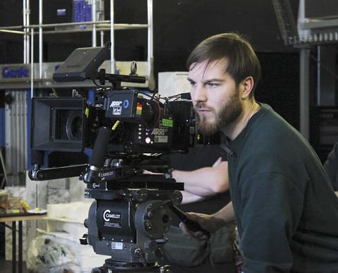 Adam Streicher operating a cinema camera on set